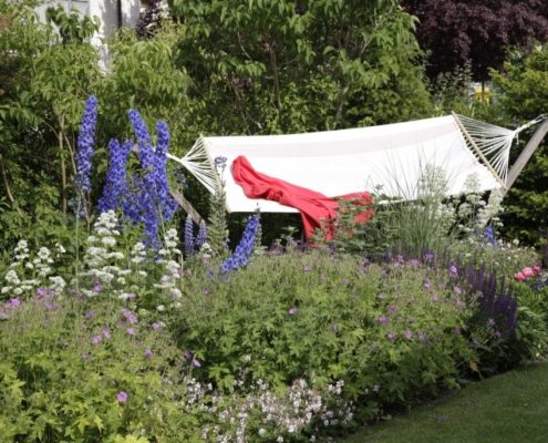 Blühender Stadtgarten mit Hängematte lädt zum Entspannen ein