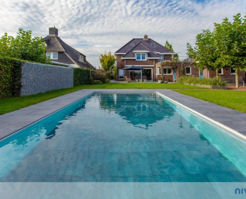 Pool mit flexibler Wassertiefe in einem Garten, Terrasse aus Naturstein