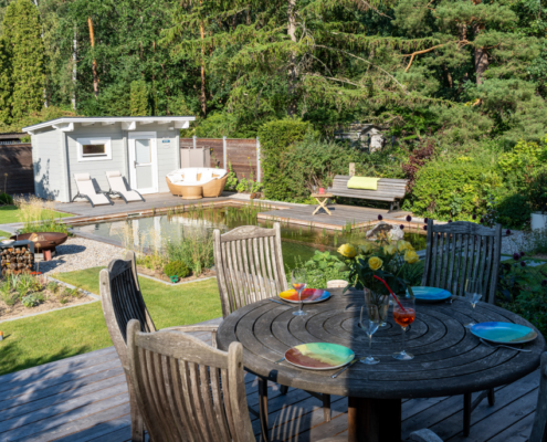 Hausterrasse mit Blick auf Schwimmteich und Sauna