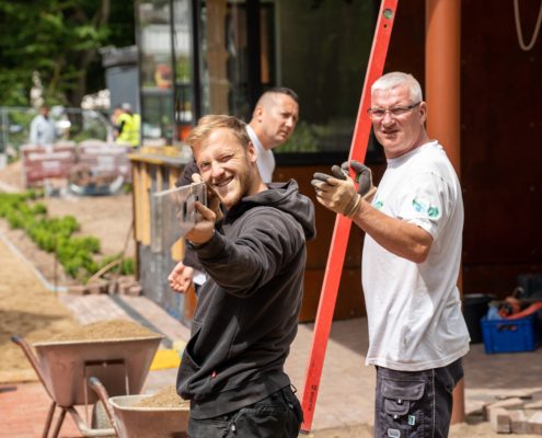 Mitarbeiter im Gartenbau mit Werkzeug in der Hand
